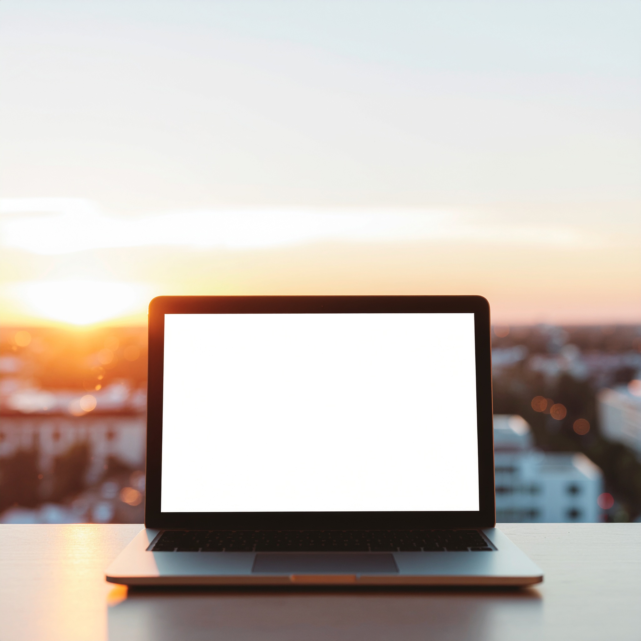 Laptop on Desk with Sunset City Background